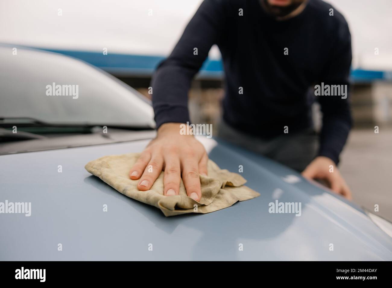 Un jeune homme heureux lavant sa nouvelle voiture. Banque D'Images