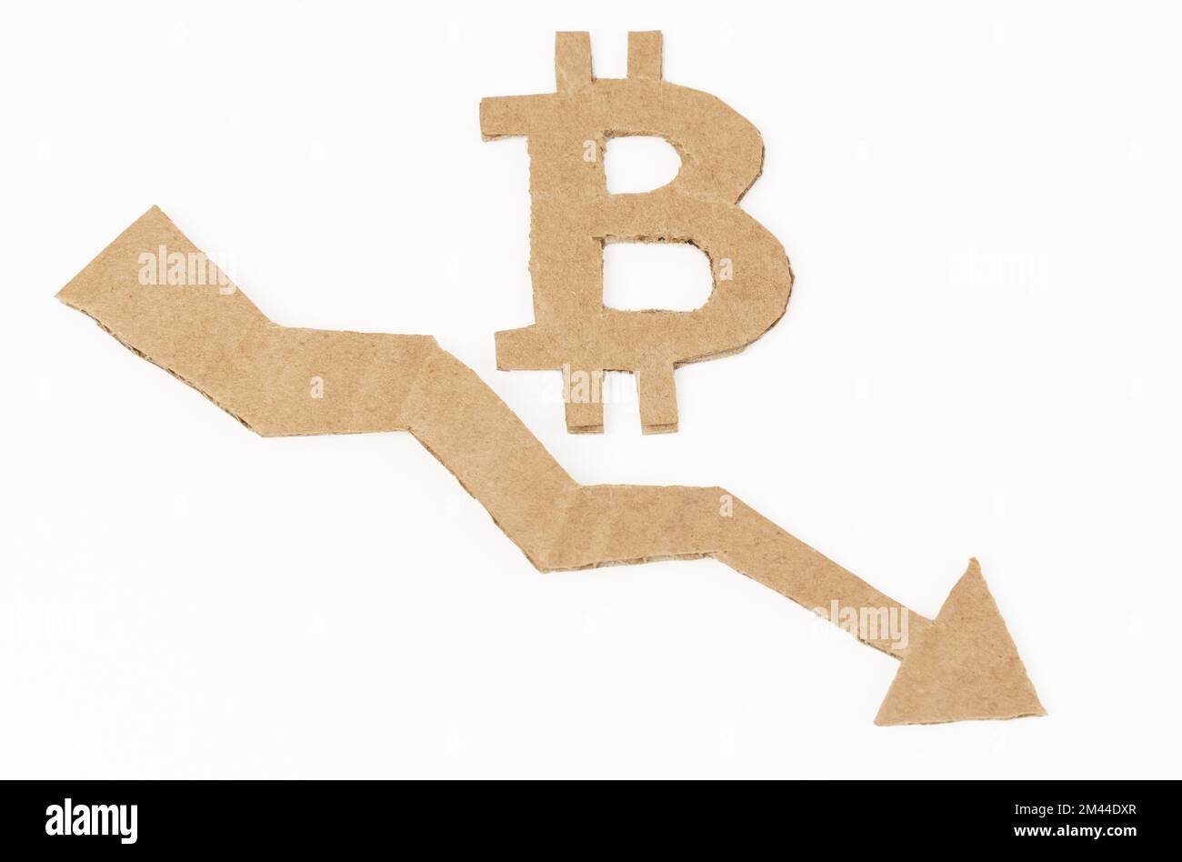 Concept de crise économique. Sur une surface blanche, un graphique avec une flèche vers le bas et un symbole de bitcoin. Le symbole, la flèche et le graphique sont en carton Banque D'Images