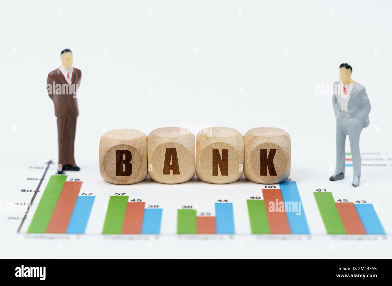 Concept commercial et financier. Sur les rapports financiers avec des graphiques, une figure d'hommes d'affaires et des cubes de bois avec l'inscription - BANQUE Banque D'Images