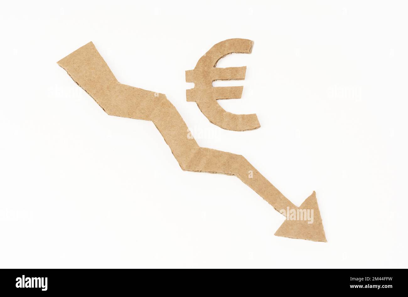 Concept de crise économique. Sur une surface blanche, un graphique avec une flèche vers le bas et le symbole de l'euro. Le symbole, la flèche et le graphique sont en carton Banque D'Images