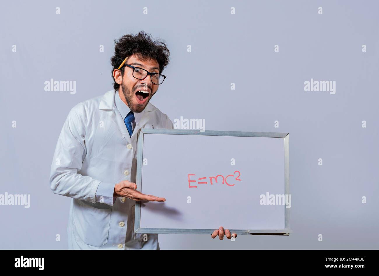 Professeur de physique tenant un tableau blanc avec une formule mathématique. Un scientifique tient et pointe vers un tableau blanc avec une formule mathématique. Scientifique Banque D'Images