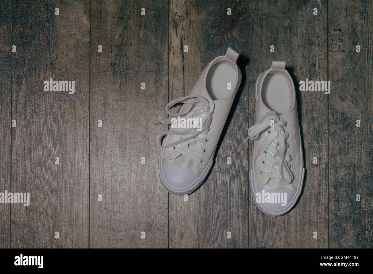 Sneakers blanches pour enfant avec effet pailleté. Sur un arrière-plan texturé Banque D'Images