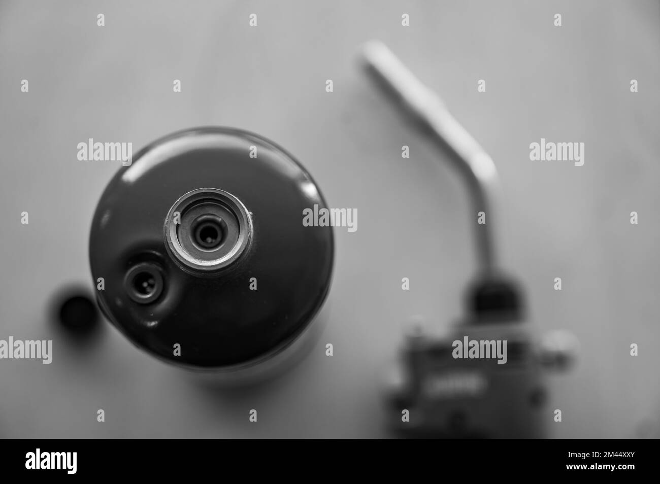 Mise au point sélective sur la cartouche de gaz propane avec buse floue et tête de torche en arrière-plan Banque D'Images