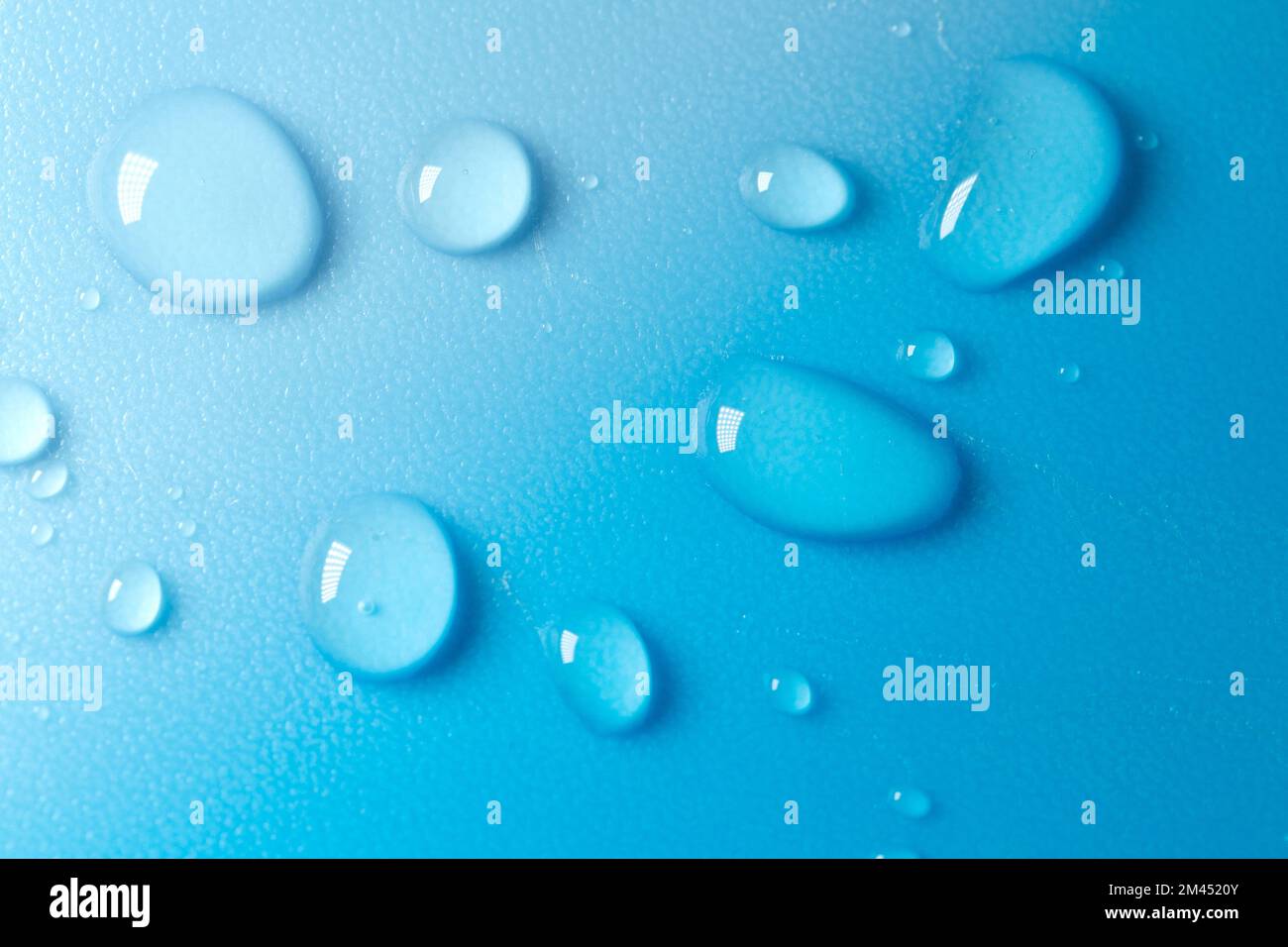 Gouttes d'eau sur fond bleu avec dégradé blanc.texture fluide dans les tons bleu froid.fond d'écran téléphone noir.gouttes macro.gouttes d'eau arrière-plan. Banque D'Images
