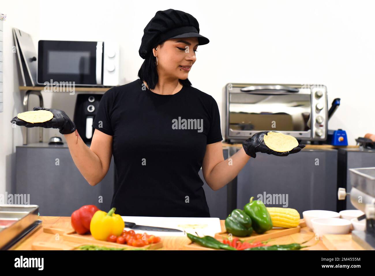 Femme mexicaine montrant des tacos pendant la cuisine Banque D'Images