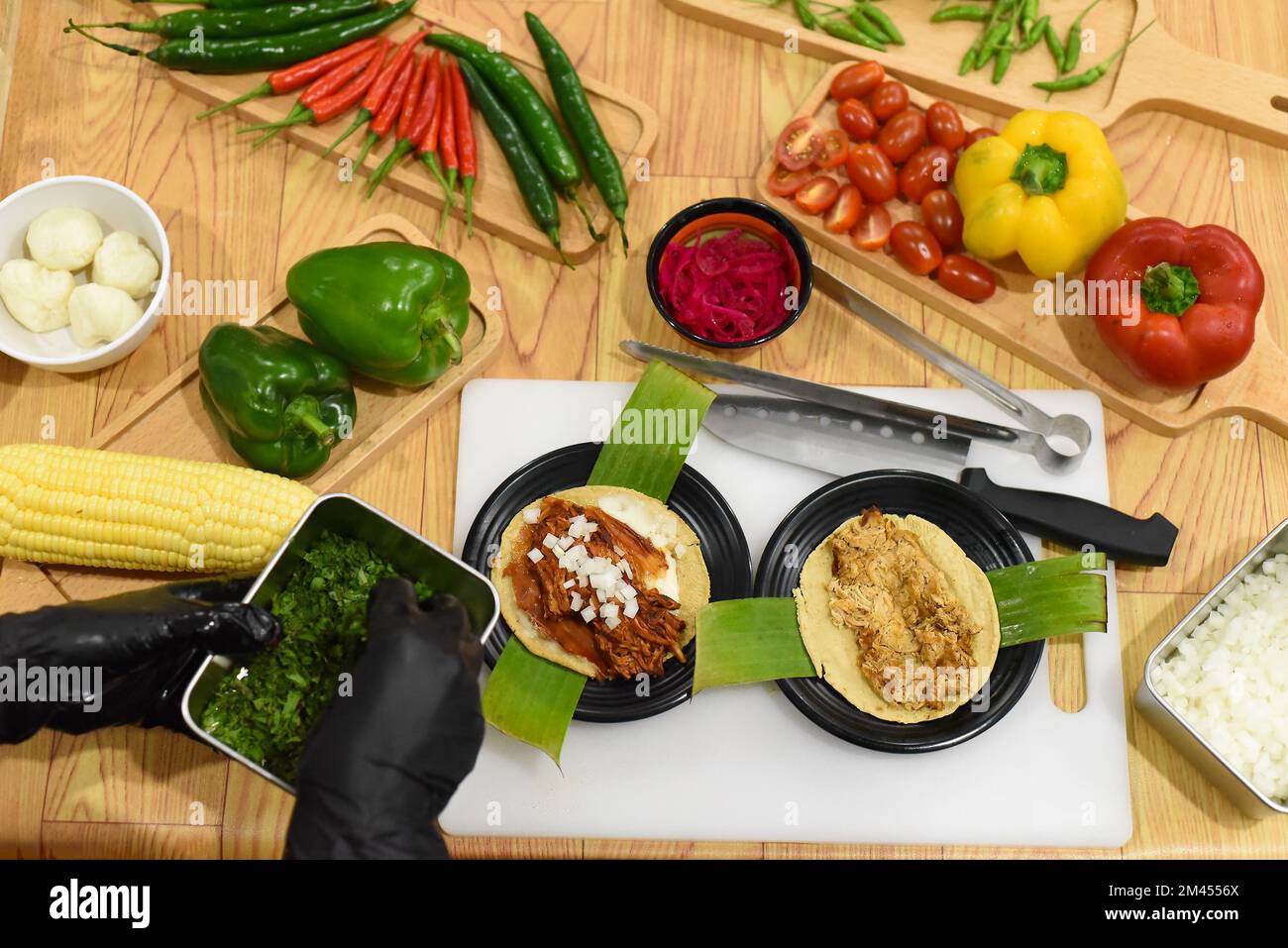 Oignon vert à la main pour préparer des Tacos dans un restaurant mexicain Banque D'Images