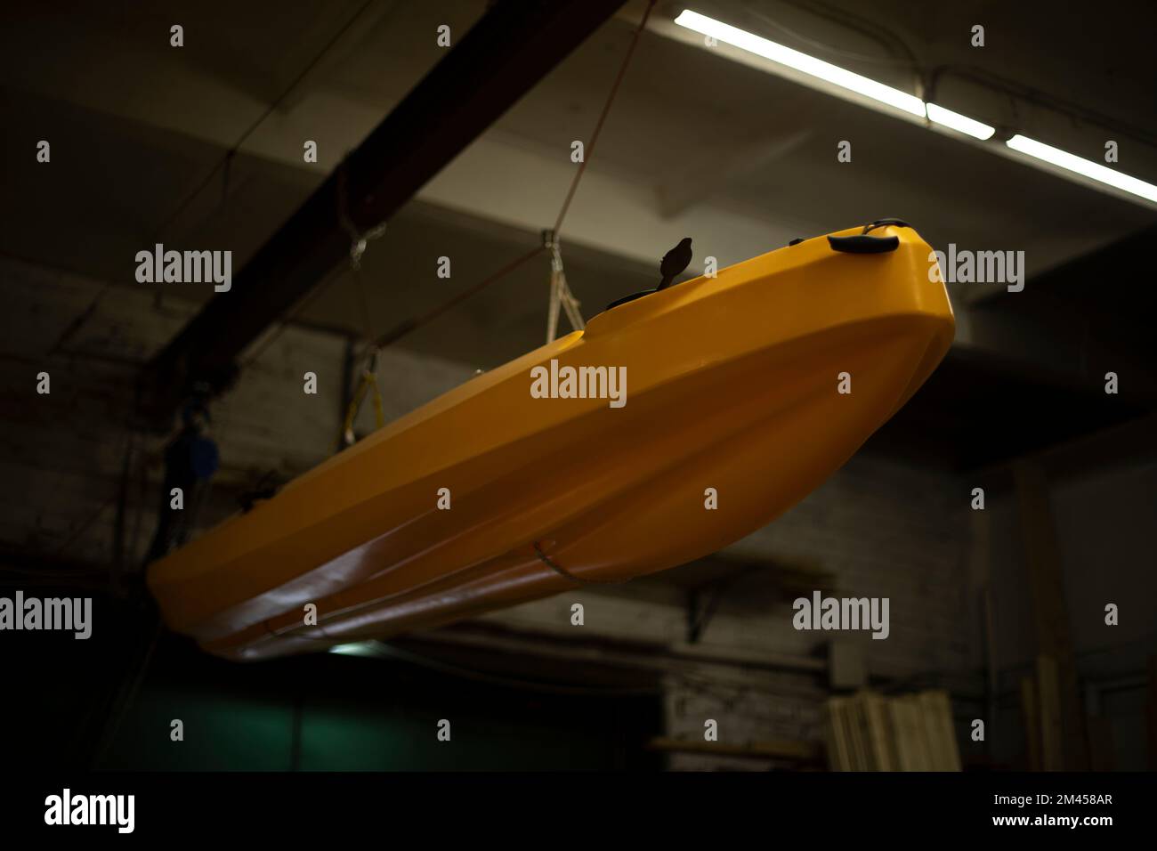 Bateau dans le garage. Le bateau est suspendu au plafond. Équipements sportifs. Transport d'eau. Véhicule. Plastique jaune. Banque D'Images