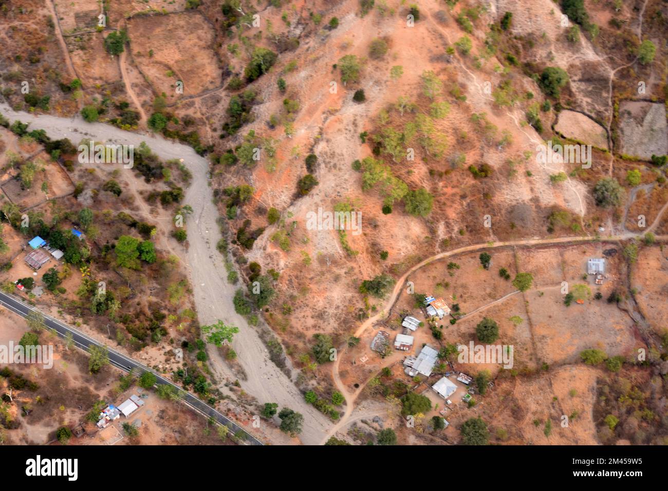 Vue sur un village dans une zone rurale au milieu des montagnes et de la rivière, vue d'en haut. Liquica, Timor oriental Banque D'Images