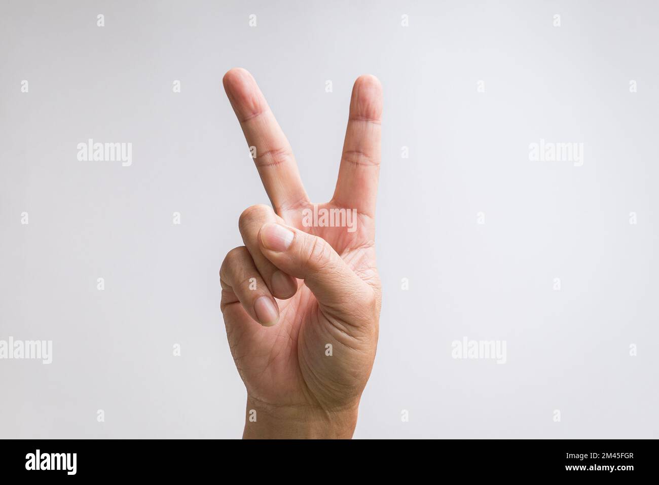 Signe de la victoire ou de la paix ou signe de la main numéro deux. Sur fond blanc. Banque D'Images