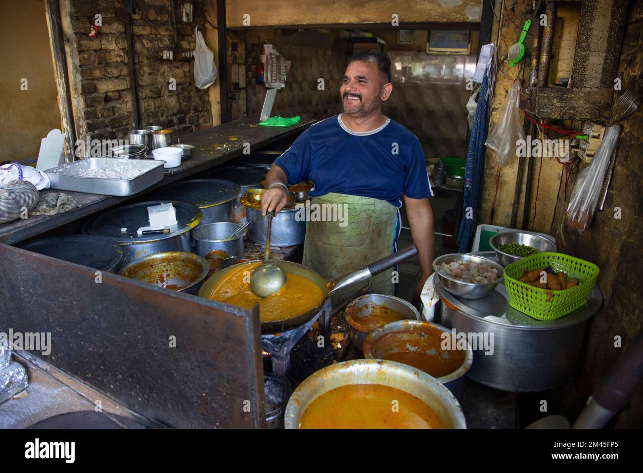 Un cuisinier et un propriétaire d'un restaurant de bord de route local ou un dhaba, cuisinant de la nourriture pendant l'heure du déjeuner Banque D'Images