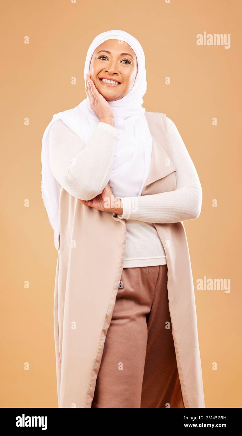Mode, beauté et portrait de la femme musulmane en studio isolé sur fond orange. Soins de la peau, cosmétiques et femme islamique mature de Dubai in Banque D'Images