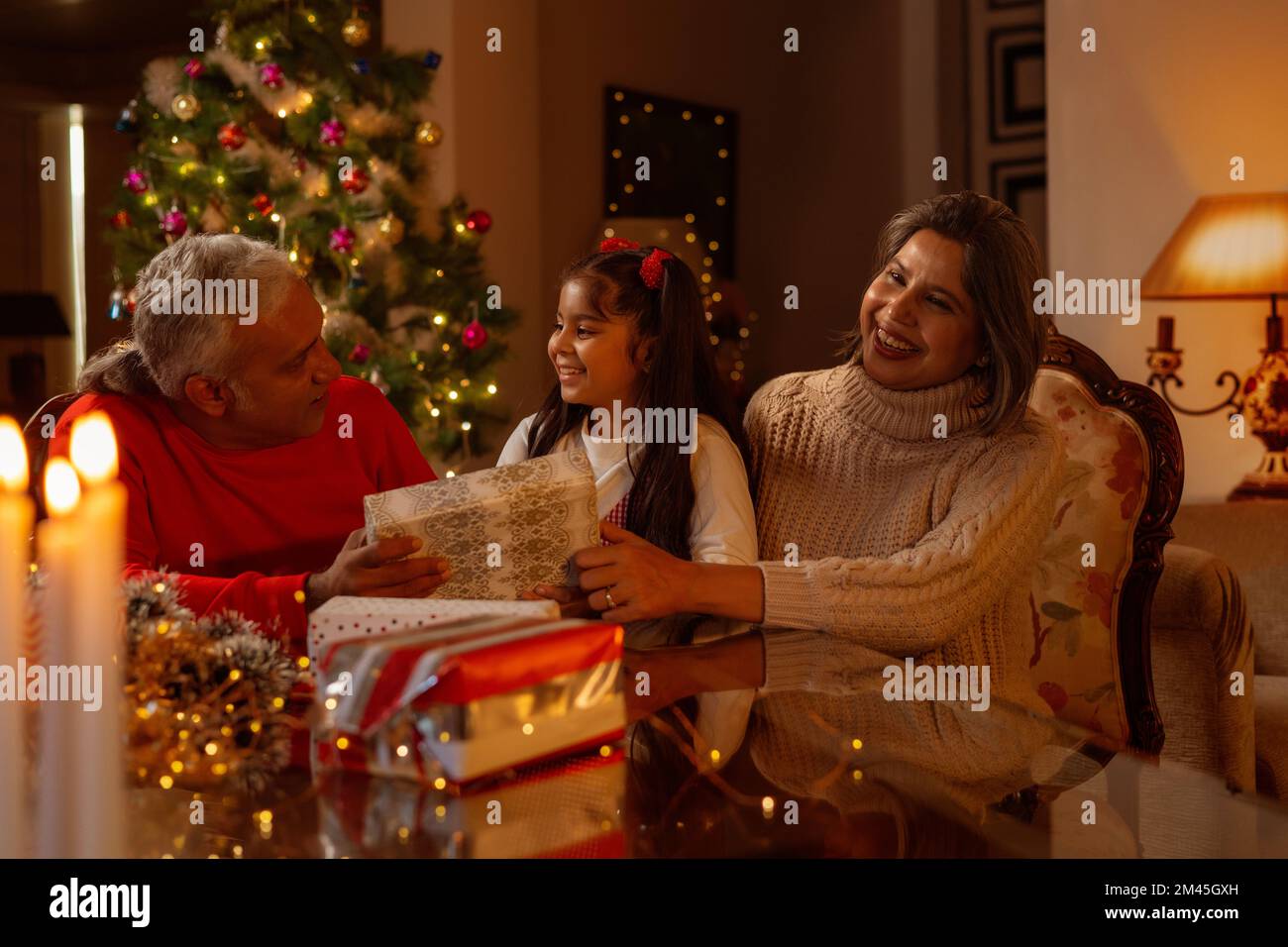 Grand-parent offrant un cadeau de Noël à leur petite-fille Banque D'Images