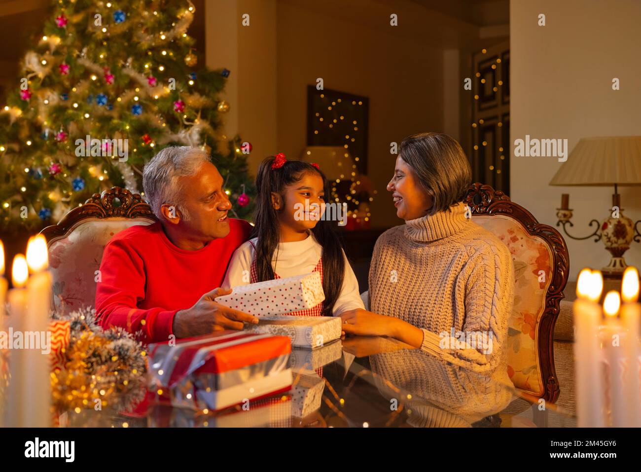 Grand-parent offrant un cadeau de Noël à leur petite-fille Banque D'Images