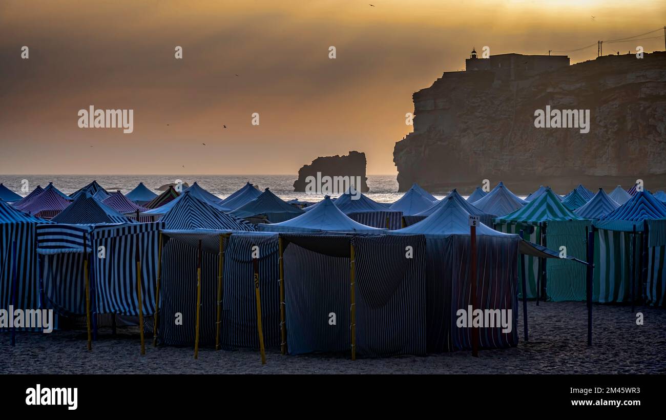 Coucher de soleil sur les cabanes de plage de Nazaré, Nazaré, Leiria, Estrémadure, Portugal. Banque D'Images
