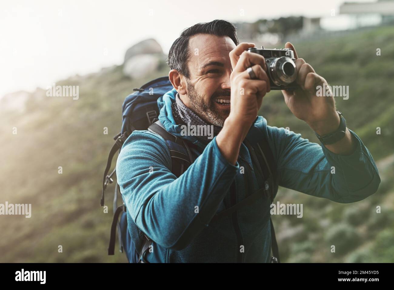 Les meilleurs moments sont toujours capturés dans l'esprit et le coeur. un homme d'âge moyen qui prend des photos avec son appareil photo dans les montagnes. Banque D'Images