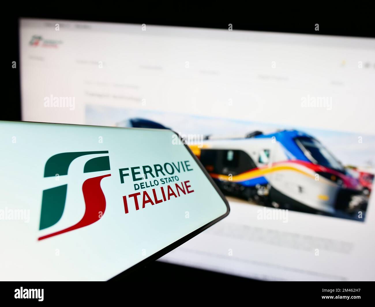 Smartphone avec logo de la compagnie ferroviaire Ferrovie dello Stato Italiane S.p.A. sur écran devant le site. Effectuez la mise au point au centre-droit de l'écran du téléphone. Banque D'Images