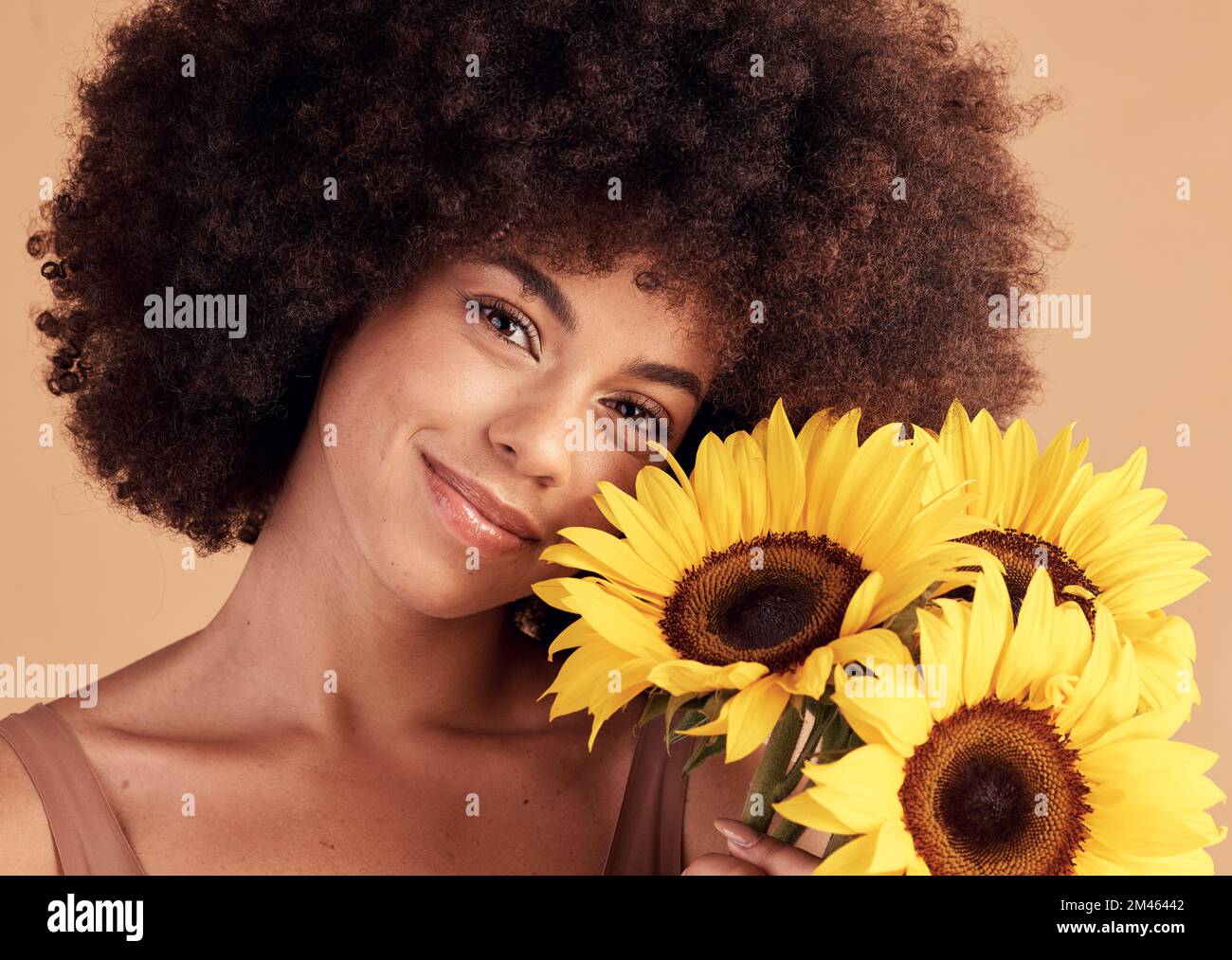 Soin de la peau, portrait de femme naturel et noir avec bouquet de tournesol pour les soins de cheveux afro, beauté et cosmétique campagne. Sourire de beau modèle avec Banque D'Images
