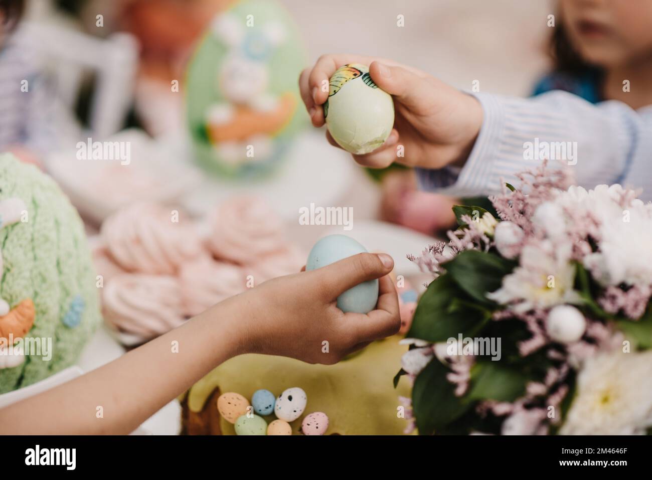 Les enfants jouent avec les œufs de Pâques colorés sur un fond flou Banque D'Images