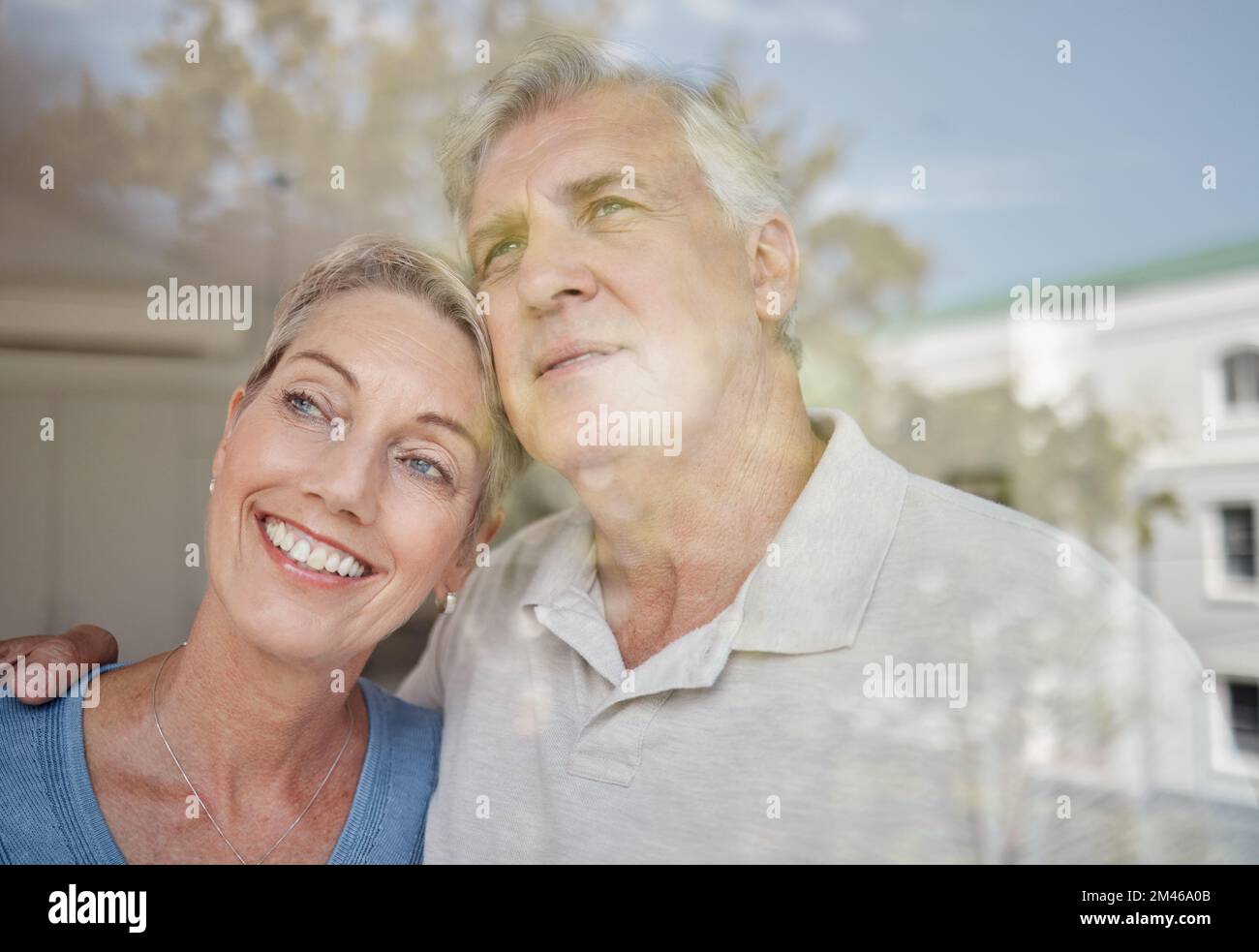 Hug, réflexion et couple senior à une fenêtre avec la vision de l'avenir, la paix de retraite et de se détendre dans leur maison. Idée, amour et homme et femme âgés avec Banque D'Images