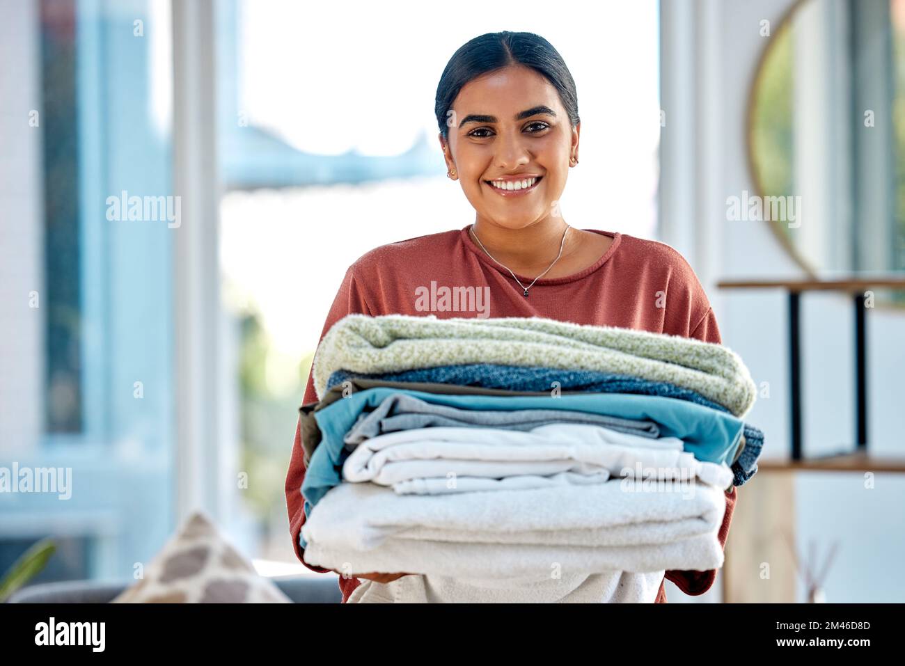 Portrait, nettoyage ou femme avec blanchisserie ou sourire heureux après avoir lavé des vêtements ou des serviettes dans les services de nettoyage. Hospitalité, hôtel ou face d'Indien Banque D'Images