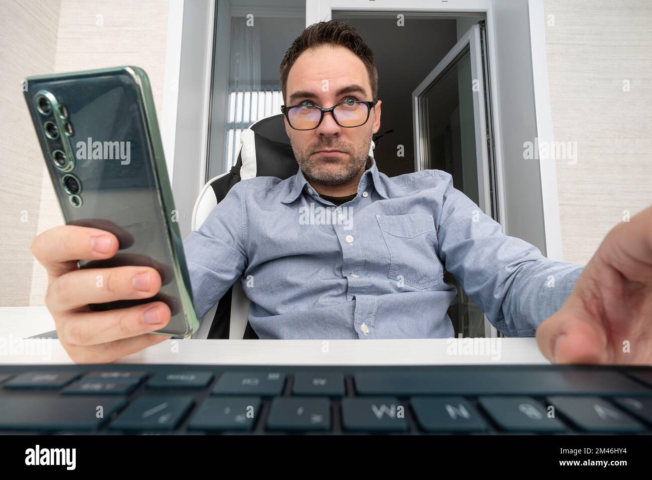 Homme d'affaires tapant sur le clavier de l'ordinateur portable et à l'aide d'un smartphone mobile. Homme d'affaires se connectant à Internet, la mise en réseau dans un bureau moderne, la proximité. wi- Banque D'Images