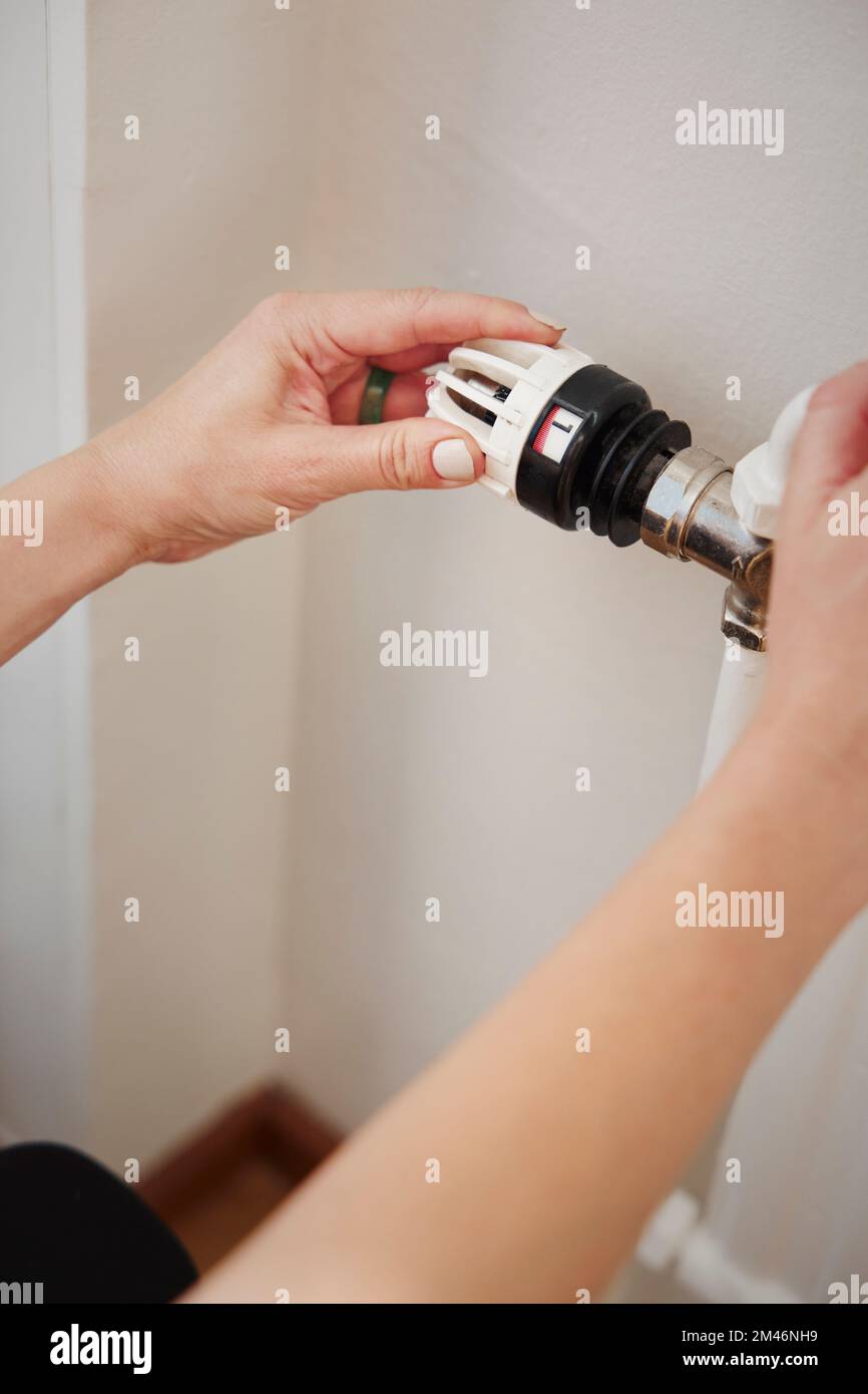 Femme utilisant un thermostat de radiateur Banque D'Images