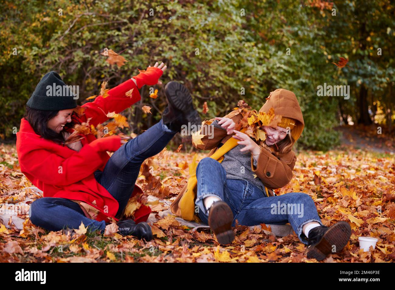 Amis jouant avec des feuilles d'automne dans le parc Banque D'Images