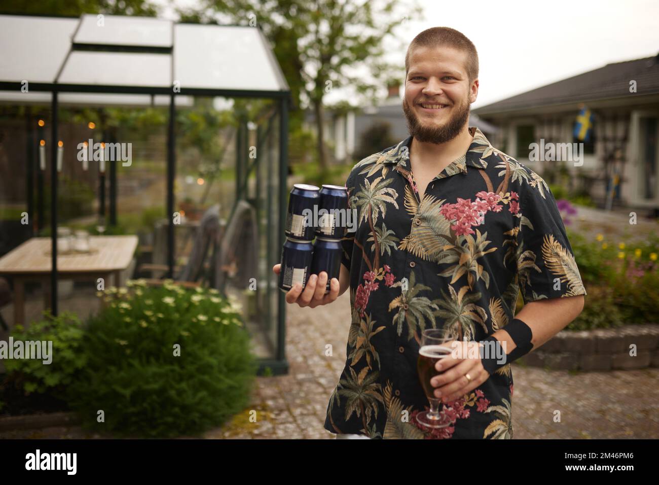 Homme souriant tenant des canettes de bière Banque D'Images