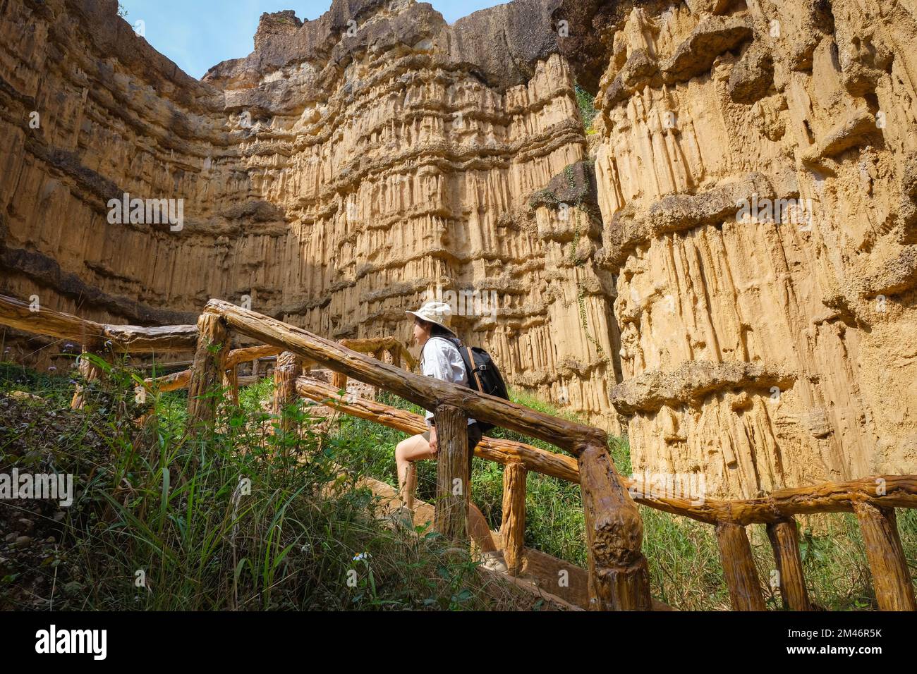 Femme géologue avec sac à dos explorant le sentier de la nature en forêt et analysant le rocher ou le gravier. Les chercheurs recueillent des échantillons de matériel biologique. Env Banque D'Images