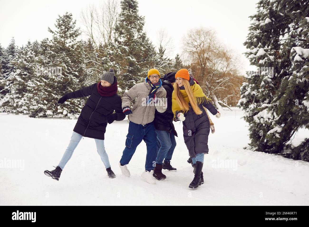 Un groupe de jeunes heureux se rencontrent dans un parc d'hiver, s'amuser et profiter d'activités de plein air Banque D'Images