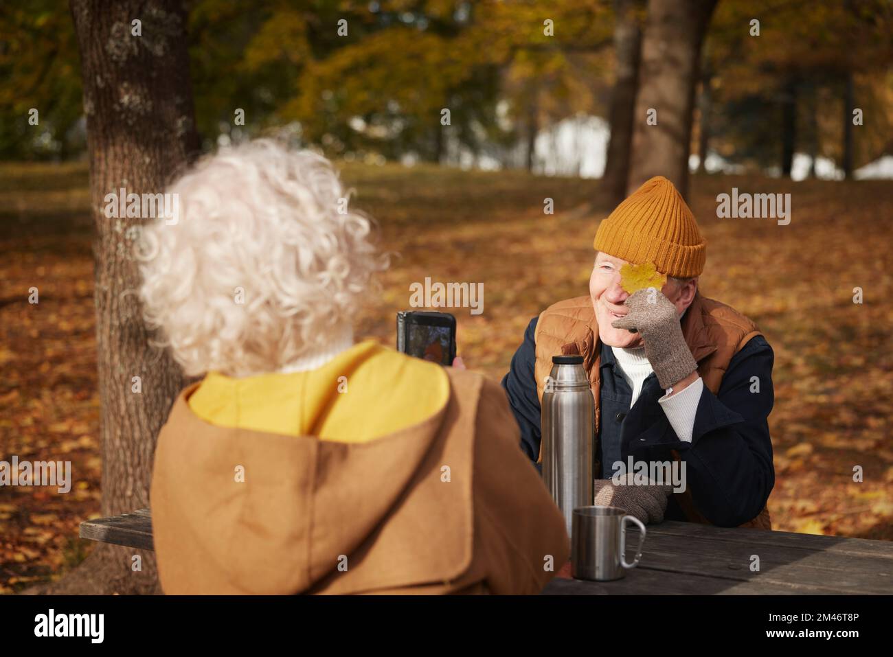 Femme senior photographiant son partenaire dans le parc Banque D'Images