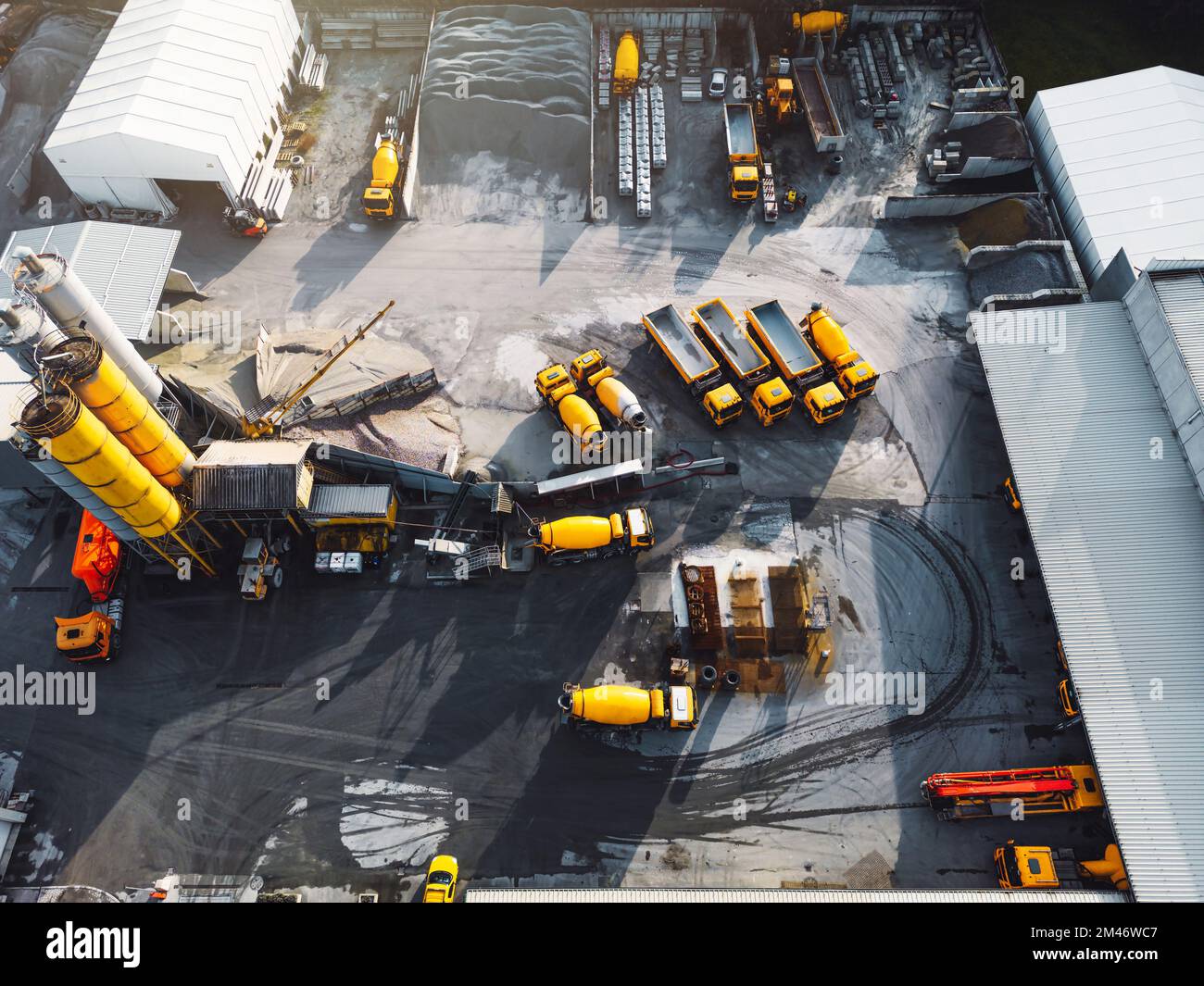 Vue aérienne du site de la société en béton avec des camions jaunes et d'autres machines lourdes garées sur le terrain Banque D'Images