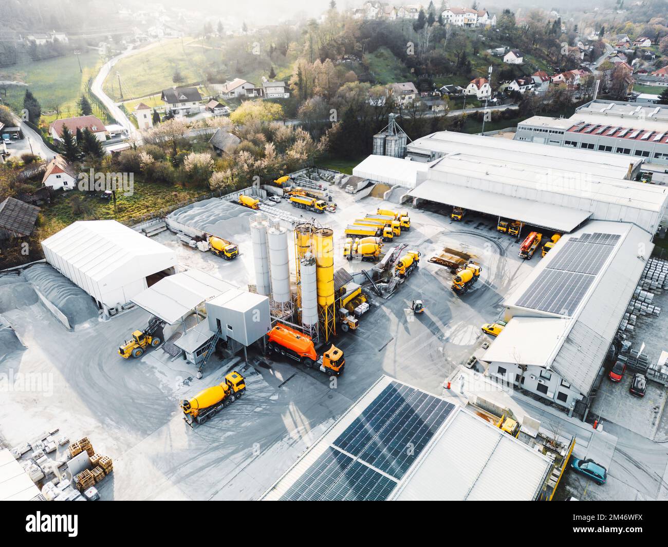 Vue aérienne de la société de construction avec beaucoup de camion jaune et de machinerie lourde garée sur le terrain Banque D'Images