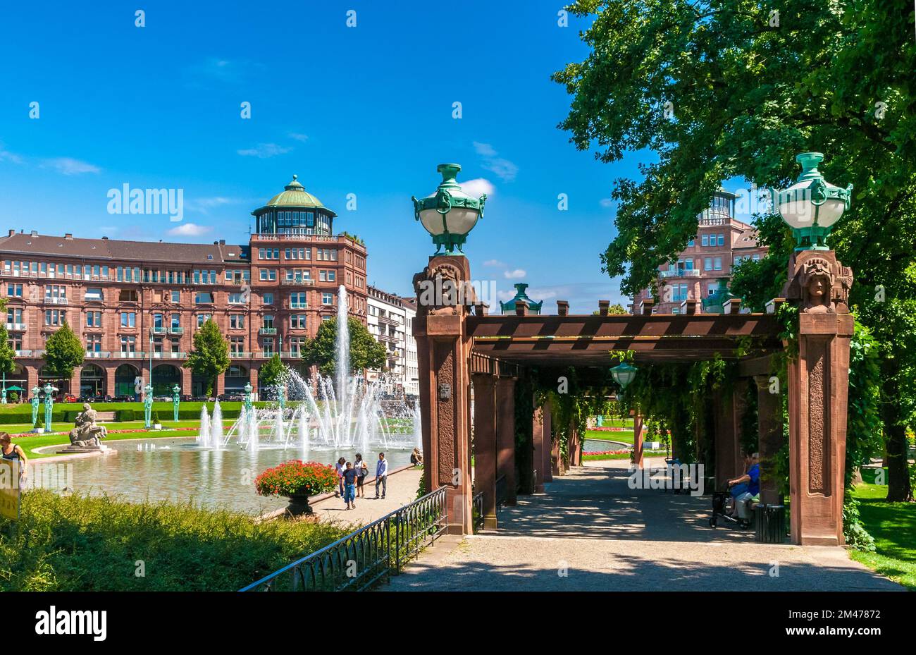 Superbe vue sur la fontaine derrière la Tour de l'eau (Wasserturm) sur la place Friedrichsplatz à Mannheim, en Allemagne, et sur la droite, la pergola... Banque D'Images