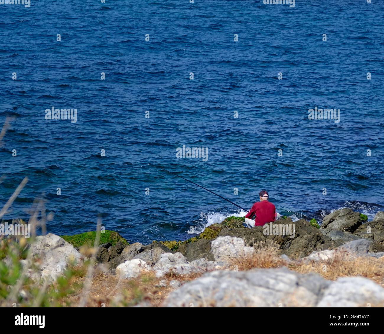 Pêcheur photographié en face de la mer en Grèce Banque D'Images