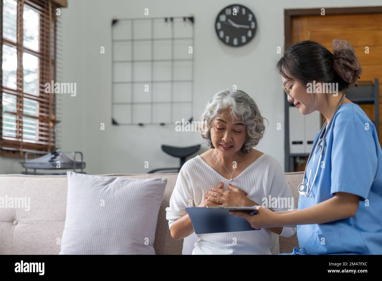 Jeune infirmière asiatique, aide à la vie, soignant à domicile ou médecin, visite d'un ancien citoyen âgé à domicile parler de la liste de contrôle de suivi des résultats Banque D'Images