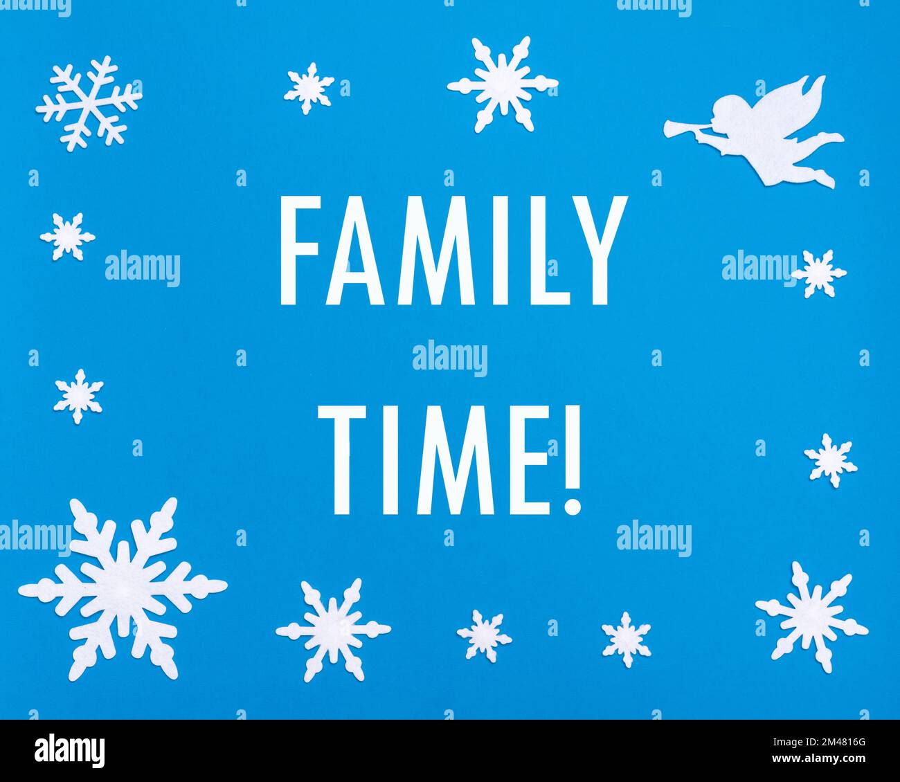 Vacances de Noël et du nouvel an. Texte temps de famille sur fond bleu avec des flocons de neige de Noël, un ange blanc jouant la trompette. Banque D'Images