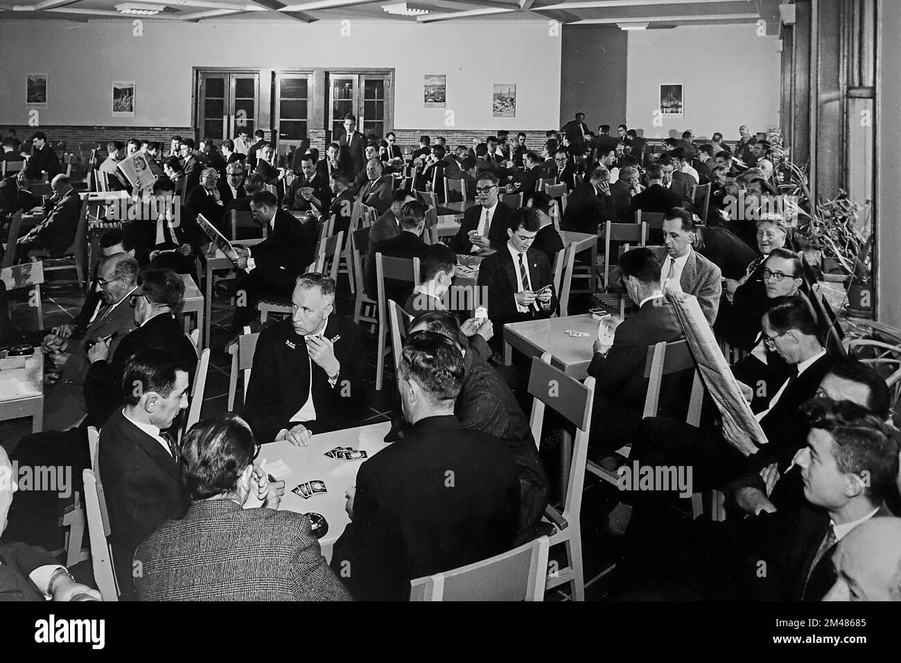 1960s salle de loisirs de la compagnie montrant des commis / employés de bureau jouant des cartes et lisant des journaux pendant la pause déjeuner Banque D'Images