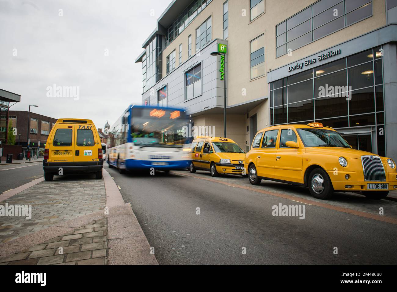 Station de taxi à derby avec motion blur de bus, Royaume-Uni Banque D'Images