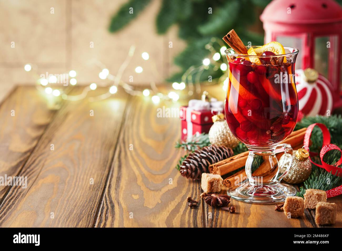 Vin chaud chaud chaud de Noël. Verres de vin chaud aux épices aromatiques cannelle, anis, sucre et branches de sapin avec bokeh et décorations. Trait Banque D'Images