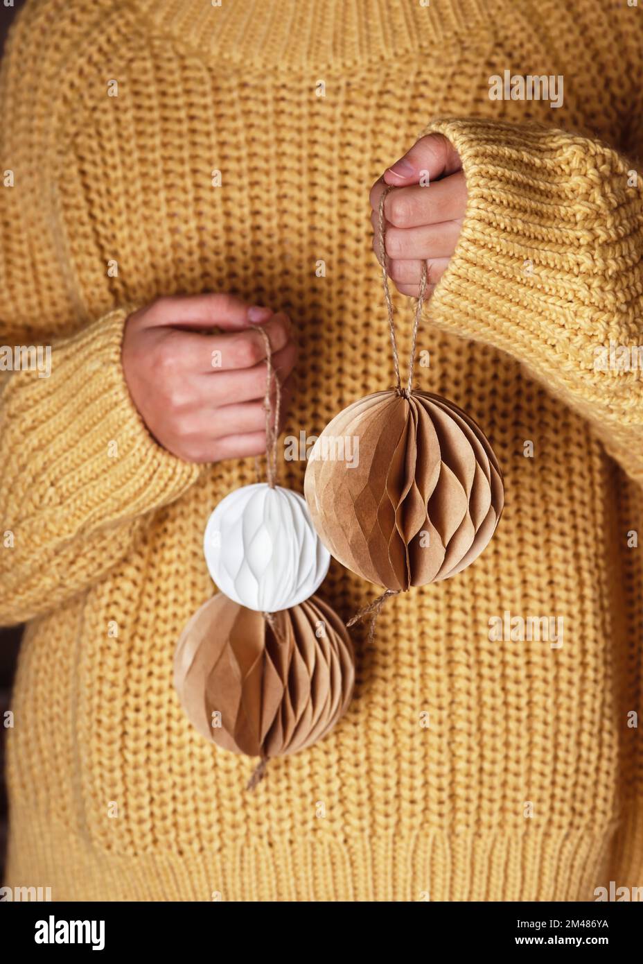 Balles de Noël faites main en nid d'abeille blanc et brun filtre à café dans les mains des filles. Concept de papier scandinave artisanal nordique. Mise au point sélective. Banque D'Images