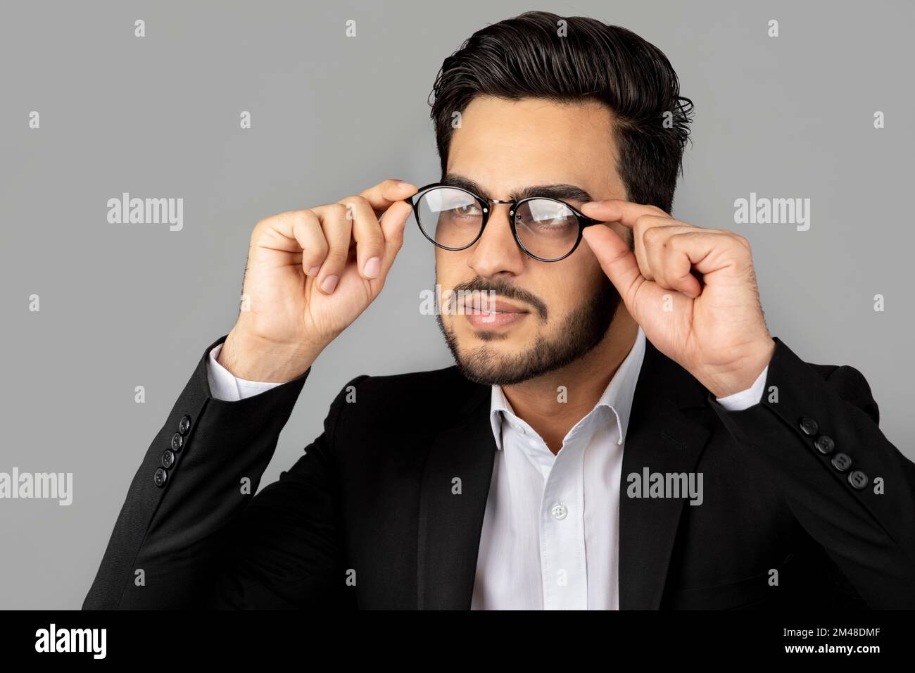 Portrait d'un jeune homme d'affaires arabe élégant portant un costume et  des lunettes de vue Photo Stock - Alamy