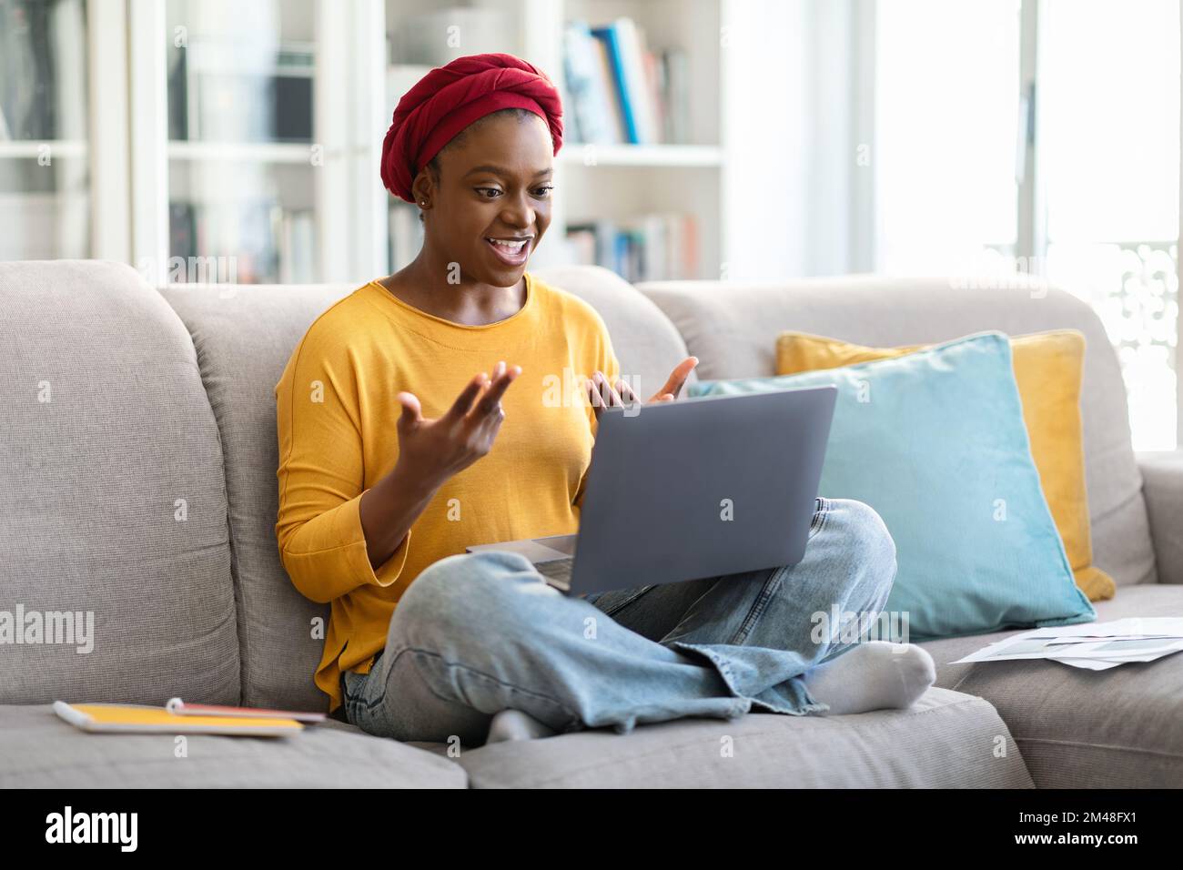 Femme noire travaillant à la maison, ayant des visioconférences avec des collègues Banque D'Images