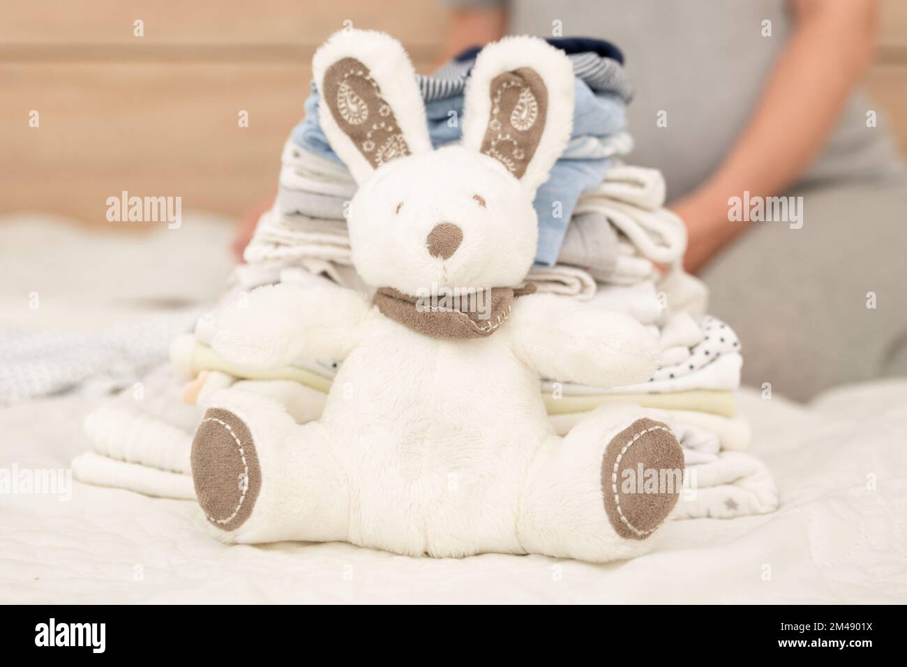 Pile de vetements pour bebe lapin et femme enceinte sur un lit Photo Stock Alamy