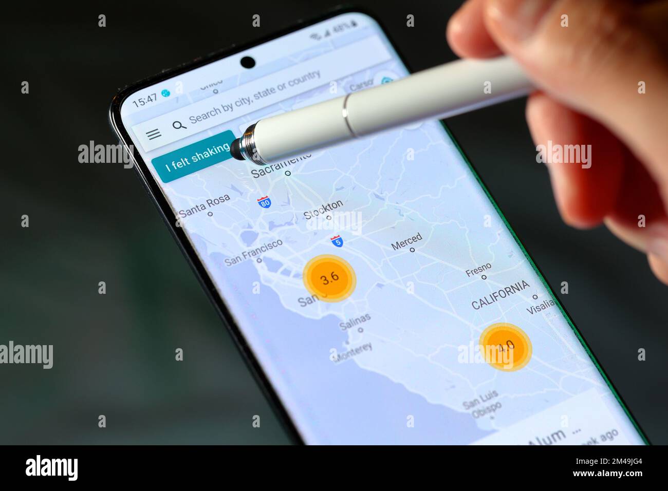 Un stylet pointe vers le bouton « Je me suis senti secoué » de l'application MyShake tremblement de terre de l'UC Berkeley Seismological Lab. Banque D'Images