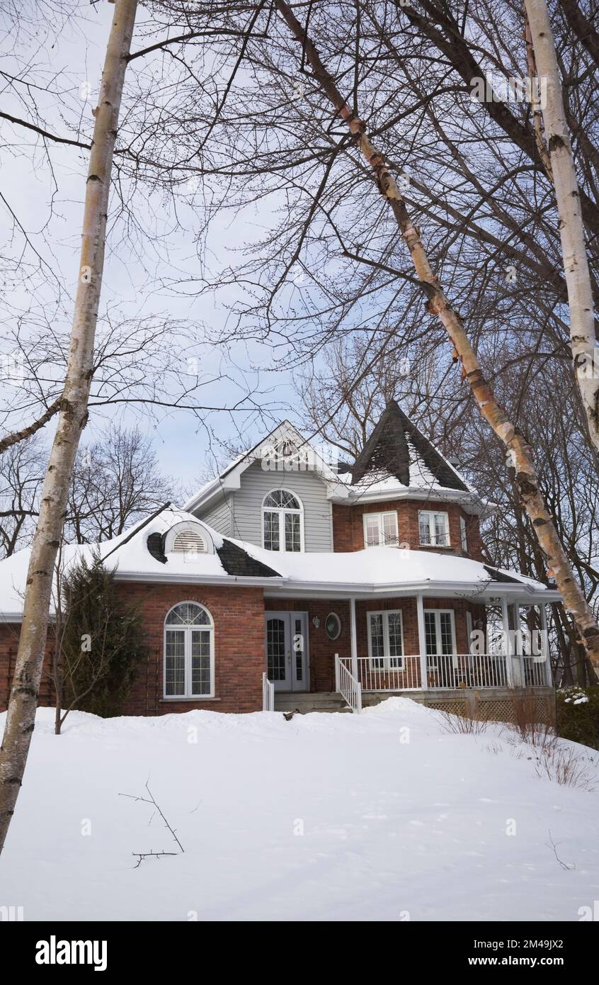 Brique rouge avec garniture grise et blanche nouvelle maison de style cottage victorien en hiver. Banque D'Images