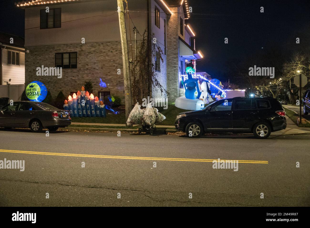 Décorations à l'extérieur d'une maison juive à Staten Island, New York, célébrant la fête juive de Hanukka - la fête de la lumière, qui a lieu en décembre - au cours de laquelle les Juifs éclairent le candélabre à 9 branches, la Menora, et jouent avec le haut tournant à 4 côtés - le Dreidel. Banque D'Images