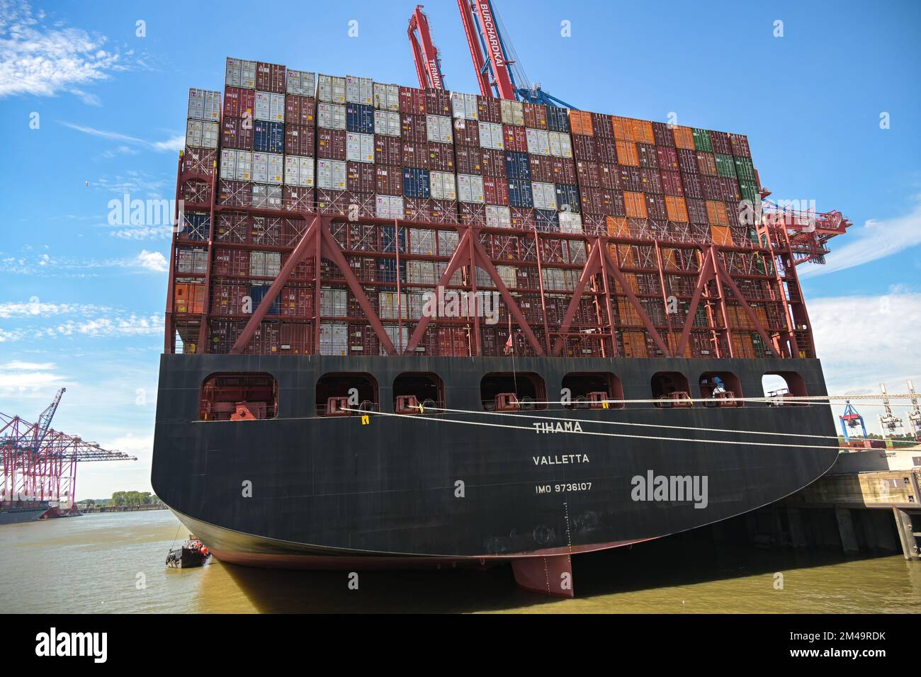 Hambourg, Allemagne, 3 août 2022: Très grand cargo Tihama derrière plein de conteneurs empilés amarrés dans le port de fret, le transport et l'intérieur Banque D'Images