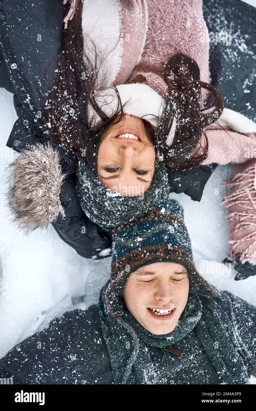 S'amuser dans la neige. Photo en grand angle d'un jeune couple heureux sur la neige. Banque D'Images