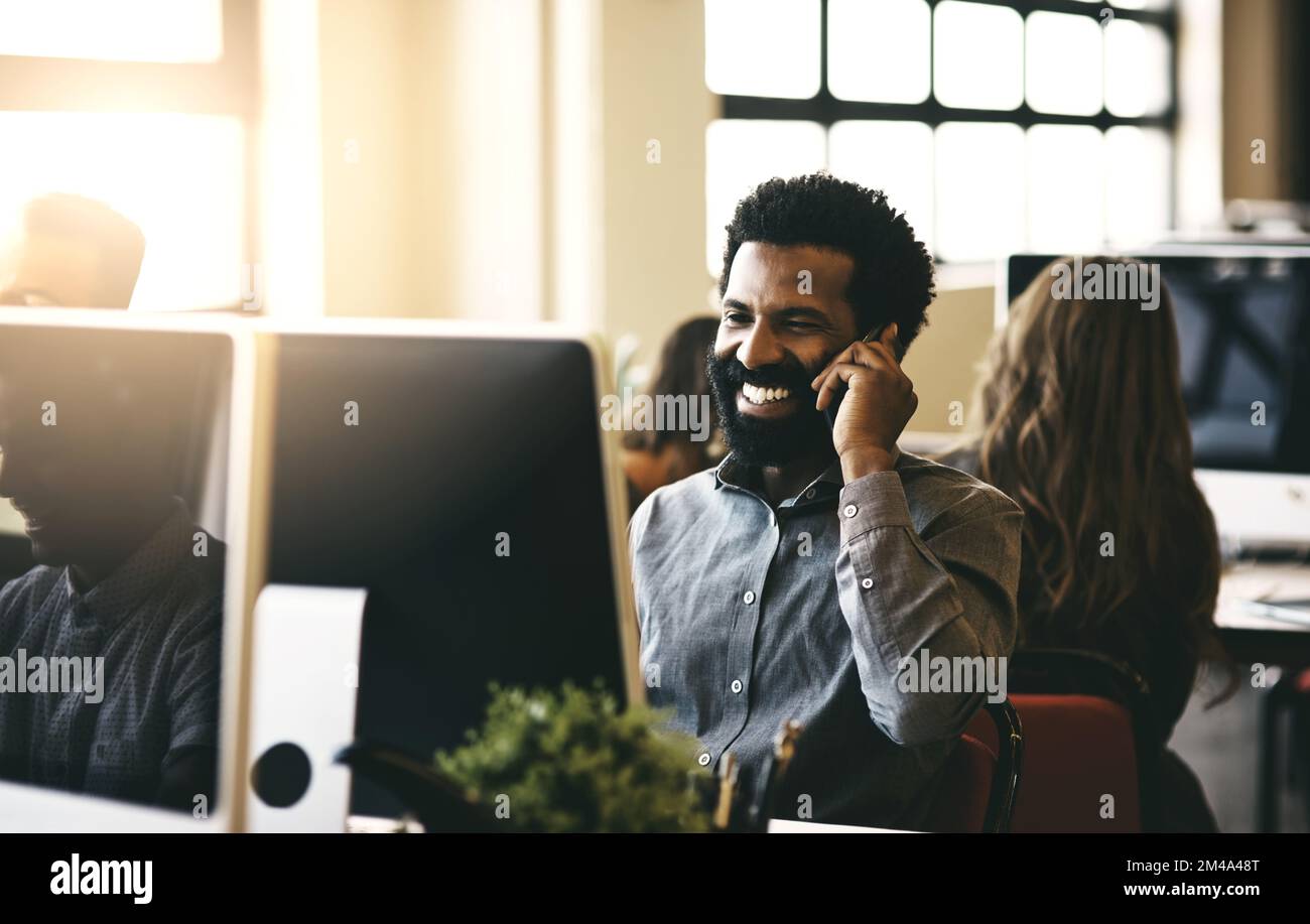 Bonjour, je viens de recevoir votre e-mail... un homme d'affaires parlant sur son téléphone tout en étant assis à son bureau. Banque D'Images